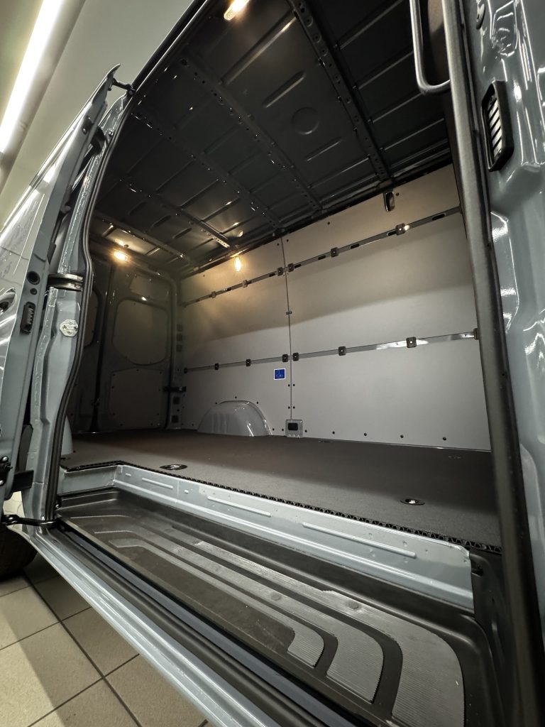 Geöffneter seitlicher Einstieg des Duisporter-Sprinters mit Trittstufe und Verzurrschienen.